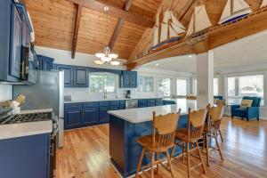 a kitchen with blue cabinets and wooden ceilings at Badin Lake Cabin with Dock and 2-Story Boat Slip! in New London