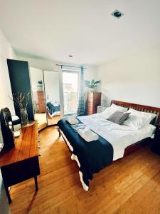 um quarto com uma cama grande e piso em madeira em Zen life with Urban Views - E8 Chic em Londres
