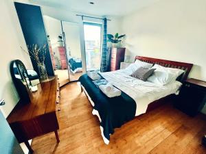 um quarto com uma cama grande e piso em madeira em Zen life with Urban Views - E8 Chic em Londres