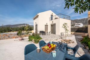 a blue table with a basket of fruit on top of a house at Pink Sand Villas in Agios Padeleimon