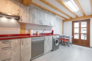 uma cozinha com um lavatório e uma máquina de lavar roupa em Gamarra - baskeyrentals em Lekeitio