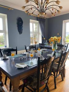 a dining room with a large table with chairs at An Riasc B&B in Ballydavid