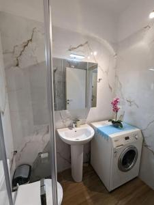 a bathroom with a sink and a washing machine at Kouriton apartment is an ideal place to relax in Gouves