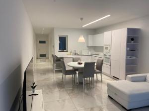 een keuken en een woonkamer met een tafel en stoelen bij A52 - Apartment with Sea and Country Views in Mellieħa