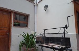 un porche con un columpio, una ventana y una planta en La Toscana en Salta
