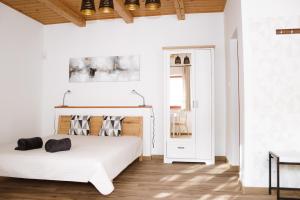 Dormitorio blanco con cama y mesa en Dunna Vendégház, en Nagymaros