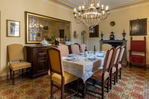 Un comedor con una mesa con sillas y una lámpara de araña. en Dimora Leone, en Lucca