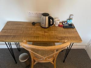 a wooden table with a coffee maker on top of it at The Bull Hotel in Downton