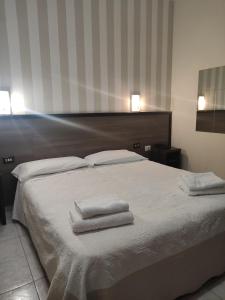 a bedroom with a bed with two towels on it at Hotel Salus in Milan