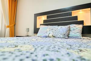 a bedroom with a bed with a black headboard and pillows at Eral Apartments Santa Catalina in Lima