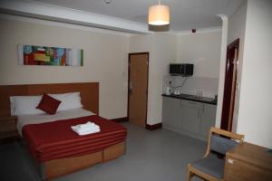 Una habitación de hotel con una cama y una cocina. en Grove Apartments, en Londres