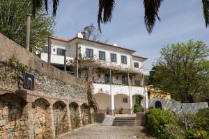 ein großes weißes Haus hinter einer Steinmauer in der Unterkunft Quinta da Paciencia in Sintra