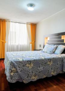 1 dormitorio con 1 cama con manta azul y blanca en Eral Apartments Santa Catalina, en Lima