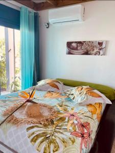 - une chambre avec un lit et une couverture colorée dans l'établissement la villa TIKALIKATA, à Saint-Joseph