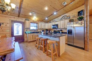 a kitchen with wooden cabinets and a stainless steel refrigerator at Broken Bow Cabin with Hot Tub and Covered Deck! in Stephens Gap