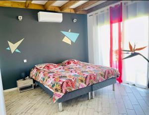 Un dormitorio con una cama y una pared con flechas. en la villa TIKALIKATA en Saint-Joseph