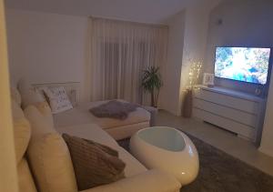 a living room with a couch and a flat screen tv at Apartman Hamad, Bihać in Bihać