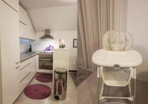 a bathroom with a sink and a chair in a kitchen at Apartman Hamad, Bihać in Bihać