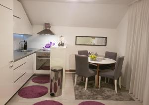 a kitchen with a table and chairs in a room at Apartman Hamad, Bihać in Bihać +12 photos