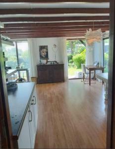 eine Küche und ein Esszimmer mit Holzböden und einem Tisch in der Unterkunft Hineni in Oostvoorne