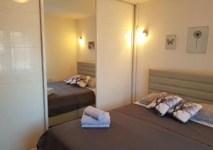 a bedroom with two beds and a mirror at Apartman Hamad, Bihać in Bihać