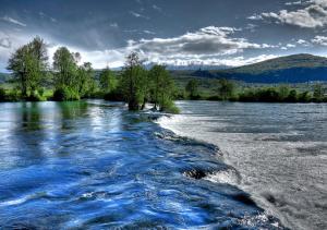 a view of a river with trees and water at Apartman Hamad, Bihać in Bihać