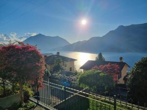 a house with a fence and a view of the water at Apartment with garden and terrace beautiful lake view in Bellano
