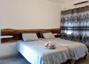 1 dormitorio con 2 camas y un bol en Savanna Tree Apartments - self catering town center, en Livingstone