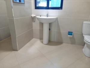 a bathroom with a sink and a toilet at Savanna Tree Apartments - self catering town center in Livingstone