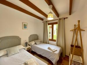 een slaapkamer met 2 bedden en een raam bij Encant in Pollença