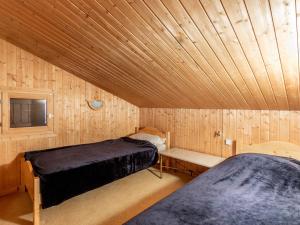 two beds in a room with a wooden ceiling at Appartement confortable avec garage et wifi dans secteur calme à Val-d'Isère - FR-1-694-154 in Val dʼIsère