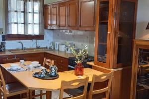 a kitchen with a wooden table with chairs and a tableablish at Giannis Traditional House in Vamos +39 photos