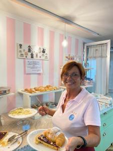 リミニにあるHotel Tre Stelleのパン屋の皿を持つ女