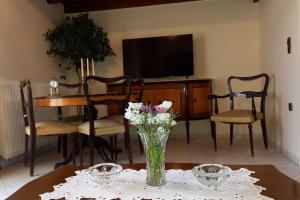 a vase of flowers on a table with a television at Giannis Traditional House in Vamos