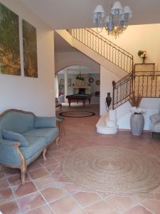 sala de estar con silla azul y escalera en Mas l aigo claro en Mouriès