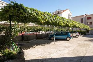 un pergolato con un'auto parcheggiata in un parcheggio di Apartment in Duce with sea view, balcony, air conditioning, WiFi 5146-4 a Duće