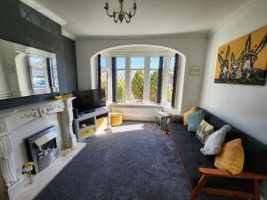 sala de estar con sofá y chimenea en Delightful newly renovated 3-bed house with garden beach hut en Blackpool