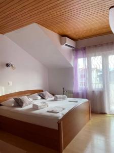 un grande letto in una stanza con una grande finestra di Apartment in Duce with sea view, balcony, air conditioning, WiFi 5146-4 a Duće