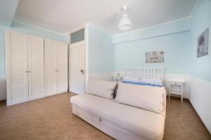 - une chambre avec un canapé blanc dans l'établissement Helios Casa Vacanze, à Alcamo Marina