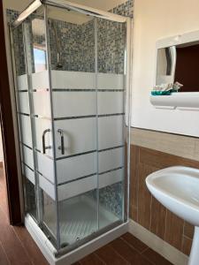 W łazience znajduje się szklana kabina prysznicowa i umywalka. w obiekcie B&B Piandelidei w mieście Sassari