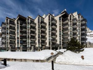 un grand immeuble dans la neige dans l'établissement Appartement rénové 2 pièces à Val-d'Isère, balcon, animaux acceptés - FR-1-694-241, à Val dʼIsère