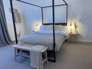 um quarto com uma cama de dossel preta e uma mesa em Sea Glass Cottage - Luxury hotel style 3 bed with hot tub em Seaham