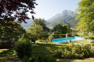 a swimming pool in a garden with mountains in the background at Appartements Greier in Telfes im Stubai