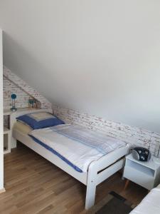uma cama branca num quarto com uma parede de tijolos em Aaron em Zierow