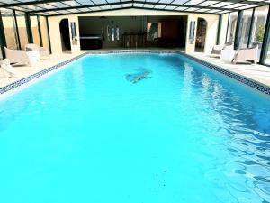 uma grande piscina com água azul numa casa em Mas l aigo claro em Mouriès