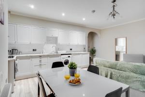een keuken en een woonkamer met een tafel met sinaasappels erop bij Rodney Street Luxury Townhouse & Apartments, Central & Stylish in Liverpool