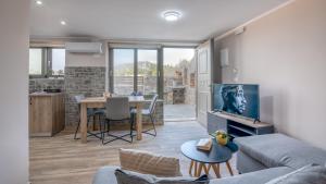 een woonkamer met een bank en een tafel bij Pink Sand-Studio in Agios Padeleimon