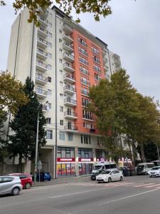 un gran edificio con coches estacionados frente a él en GSS - B Apartment en Tiflis