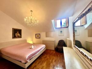 1 dormitorio con cama y lámpara de araña en [Monzuno] Elegant Mansarda, en Monzuno