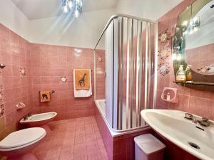 Baño de color rosa con aseo y lavamanos en [Monzuno] Elegant Mansarda, en Monzuno